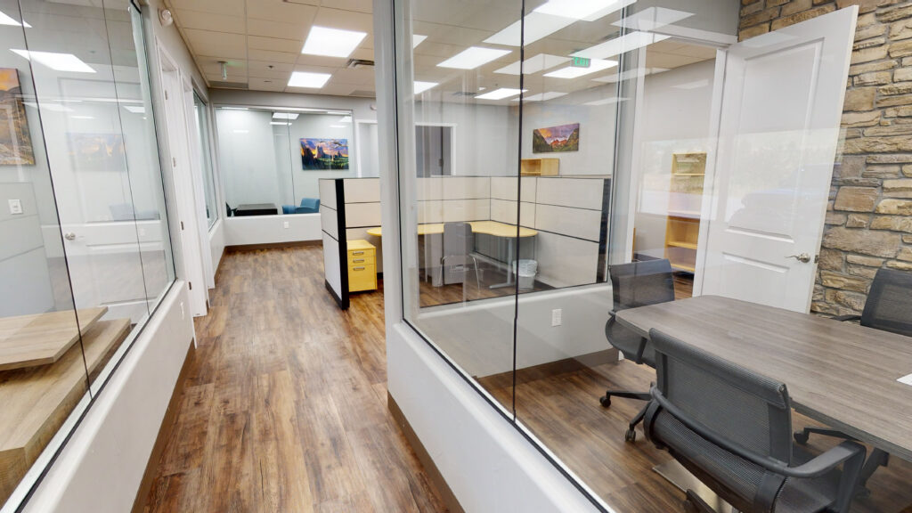 Bright office suite with glass-walled private offices and wood floors