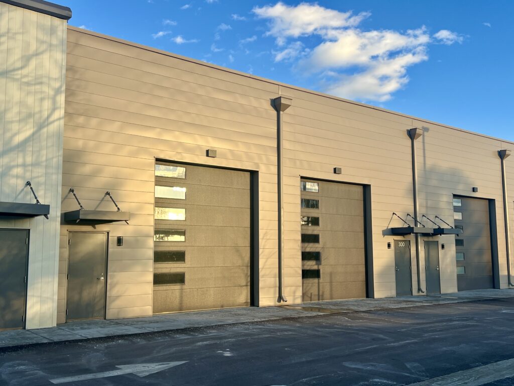 Modern flex condo building with overhead doors and storefront entries