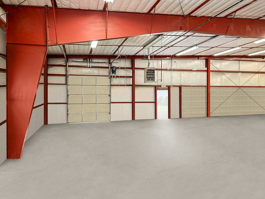 Clear-span warehouse interior with drive-in door and sealed concrete floor